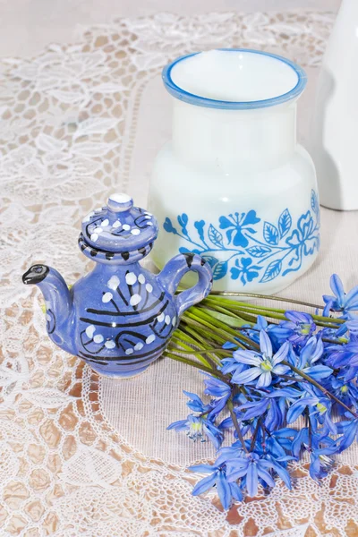 Bluebel, vase and teapot on a lace tablecloth, still life — Stock Photo, Image