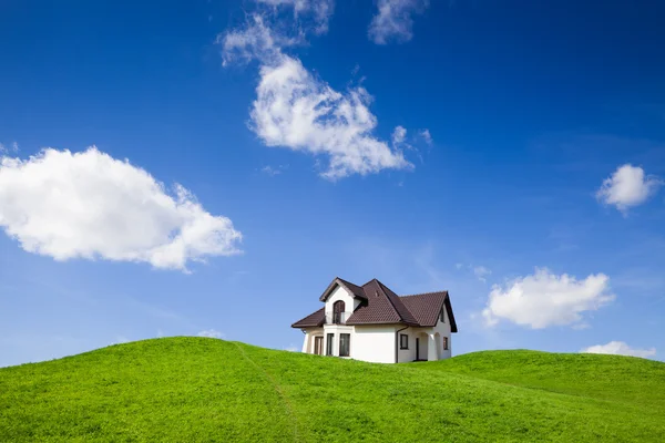 Nieuw huis op groene veld — Stockfoto