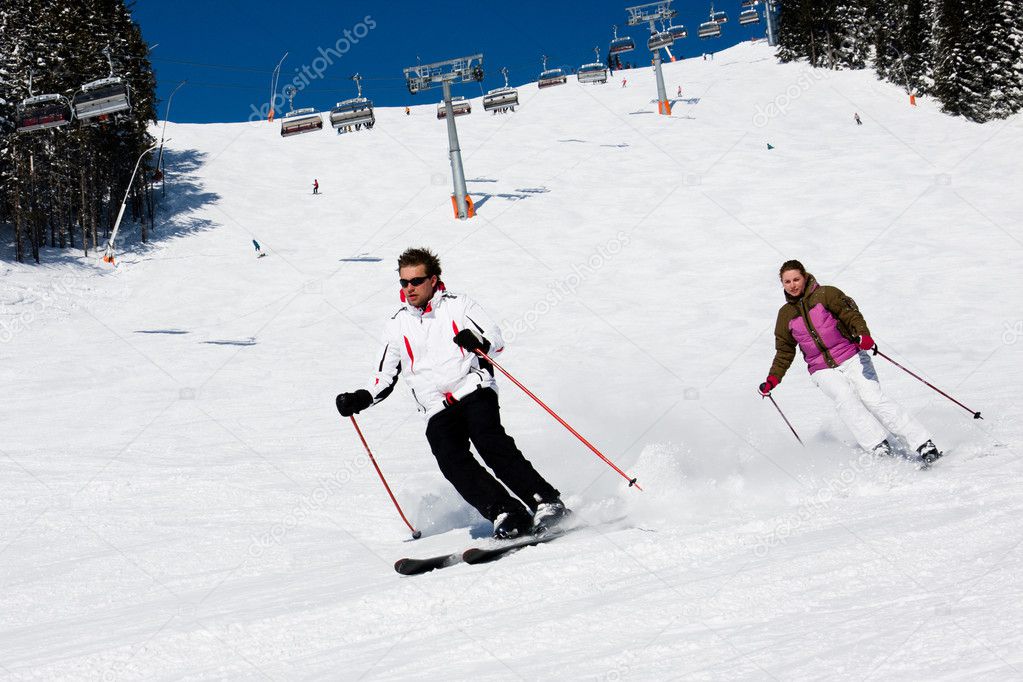 Two skiers downhill skiing