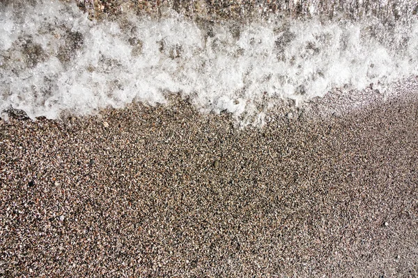 Wave on clear gravel beach — Stock Photo, Image