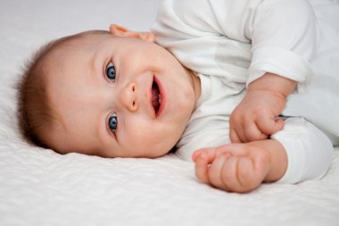 Boy laying on bed amd smiling clipart