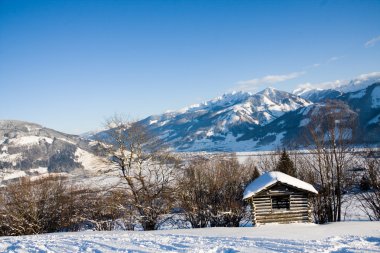 Small cottage in alps in winter clipart