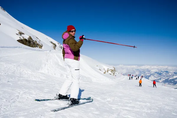 Женщина указывает на лыжный склон — стоковое фото