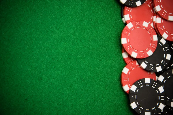 Black gambling chips on green felt background — Stock Photo, Image