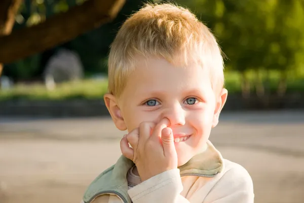 Boy picking his nose outdoors — Stock Photo, Image