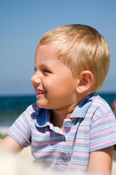 Malý chlapec, usmívající se na pláži — Stock fotografie