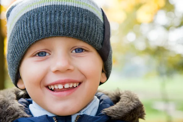 Junge lächelt im Herbsttag — Stockfoto