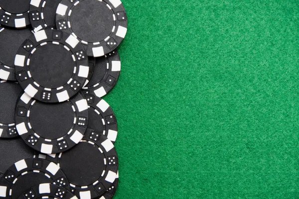 Red gambling chips on green felt background with copy space