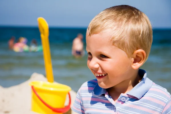 Küçük bir çocuk kumsalda gülümseyen — Stok fotoğraf