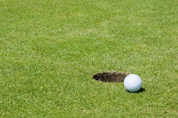 Piłeczki do golfa w pobliżu otworu — Zdjęcie stockowe