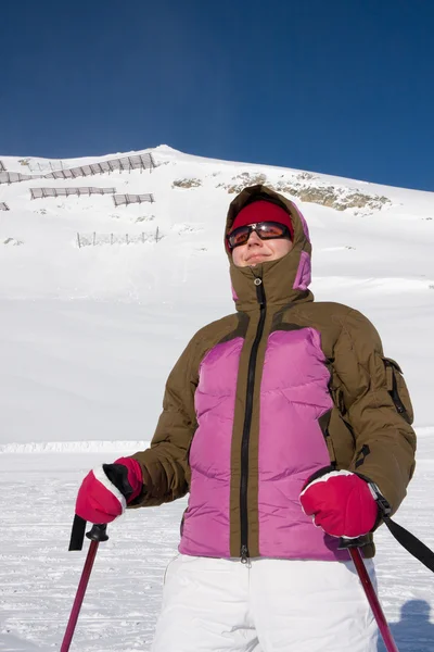 Mujer esquiadora en traje de esquí de pie frente a la montaña — Foto de Stock