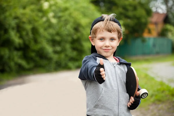 Boy showing thumbs up sign outdoors — Stock Photo, Image