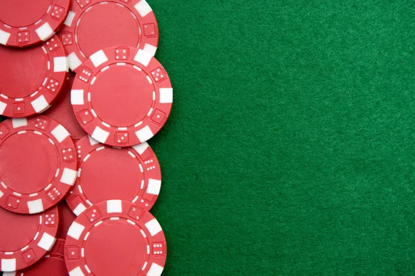 Red gambling chips on green felt background with copy space — Stock Photo, Image