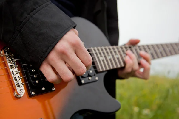Närbild av en man som spelar gitarr — Stockfoto