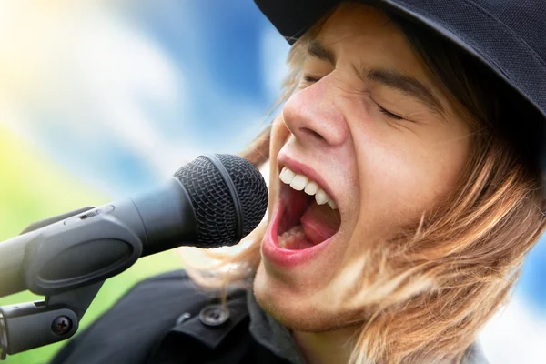 Young man sings to microphone