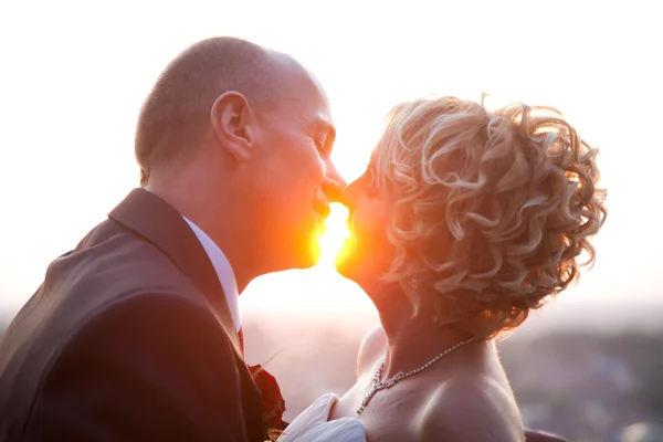 Menyasszony és a vőlegény a naplemente csók — Stock Fotó