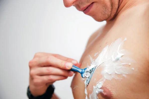 Young man shaving his chest, torso — Stock Photo, Image