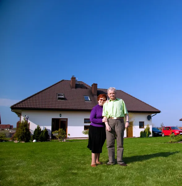 Senior couple in front of the house — Stock Photo, Image