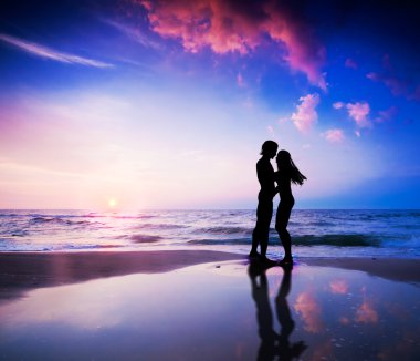 Romantic couple on beach at sunset clipart