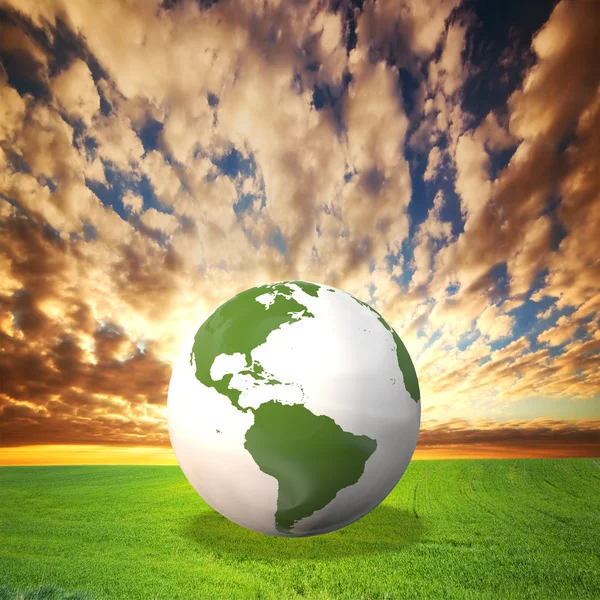 Planeta Země model na zelené louce při západu slunce — Stock fotografie