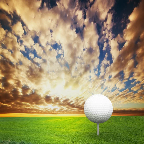 Hrát golf. míč na odpališti, golfové pole při západu slunce — Stock fotografie