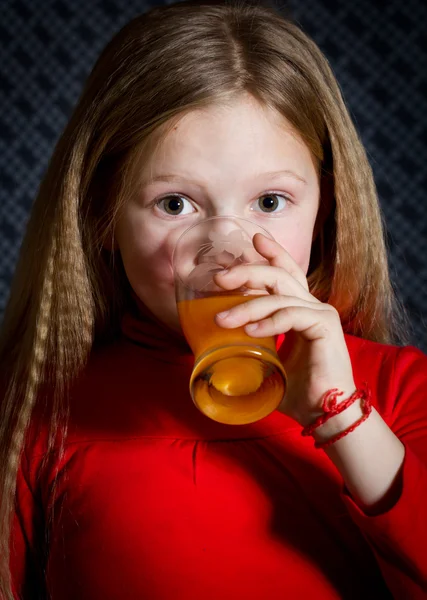 Красивая маленькая девочка со стеклом в руках — стоковое фото