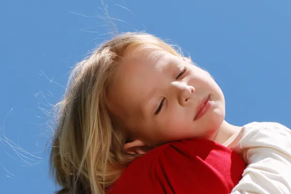 Маленькая девочка спит на плече у матери на фоне неба — стоковое фото