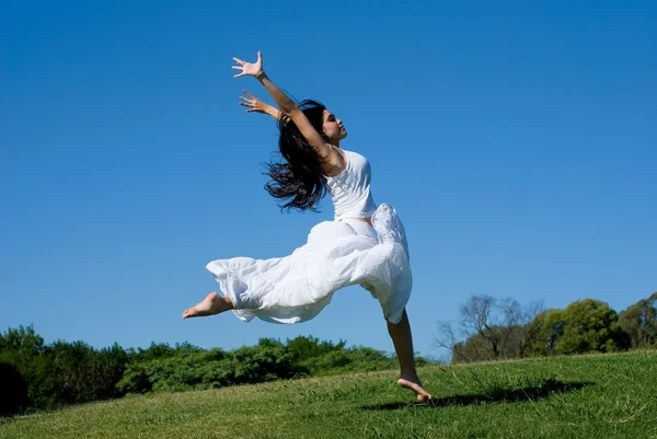 Щаслива дівчина стрибає в білій сукні — стокове фото