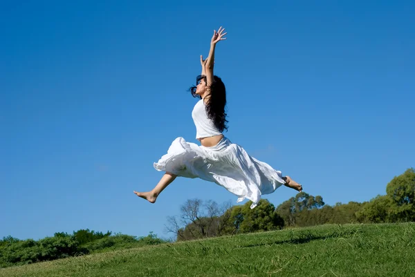 Šťastná dívka, která skočila v bílých šatech — Stock fotografie