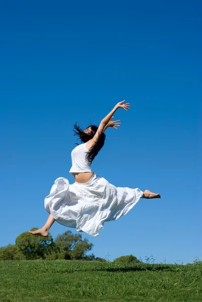 Szczęśliwa dziewczyna skoki w białej sukni — Zdjęcie stockowe