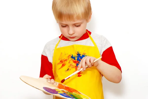 Маленький мальчик с кистью и палитрой художника с несколькими цветами — стоковое фото