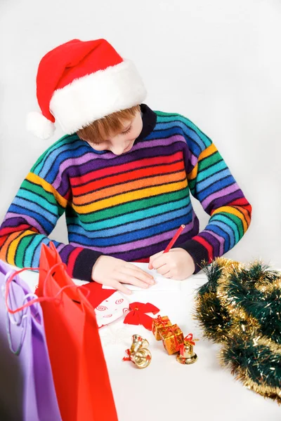 Den vackra pojken skriver brevet till jultomten — Stockfoto