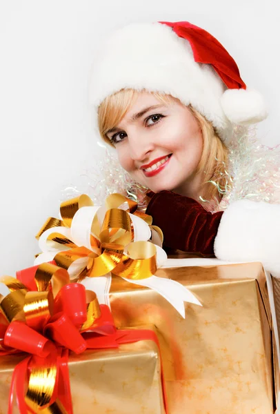 Belle femme dans une robe rouge et chapeau de Père Noël avec un grand cadeau — Photo