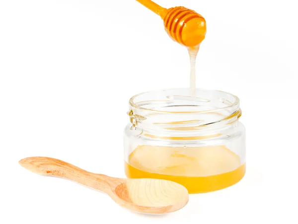 Frasco de mel com garoa de madeira sobre fundo branco — Fotografia de Stock