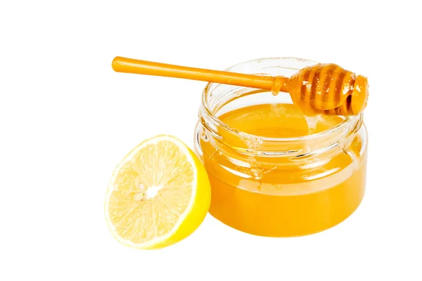 Frasco de mel com um drizzler de madeira e um limão . — Fotografia de Stock