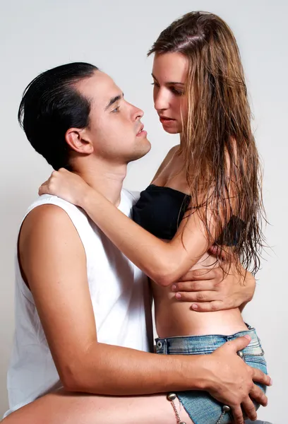 Jeune couple intime pendant les préliminaires sur un fond clair — Photo