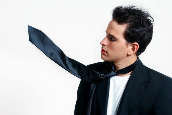 stock image Portrait of the informal young guy with a magic tie on a light b