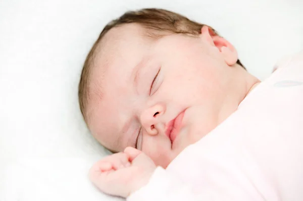 Baby slaap onder een witte deken — Stockfoto