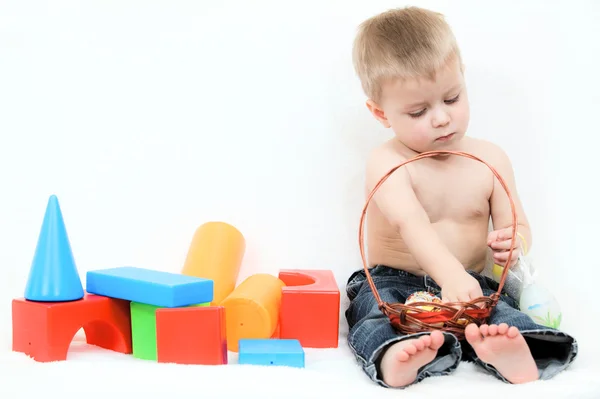 Baby, umgeben von Spielzeug auf weißem Hintergrund — Stockfoto