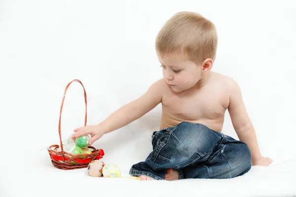 De kleine jongen met Pasen eieren op een witte achtergrond — Stockfoto