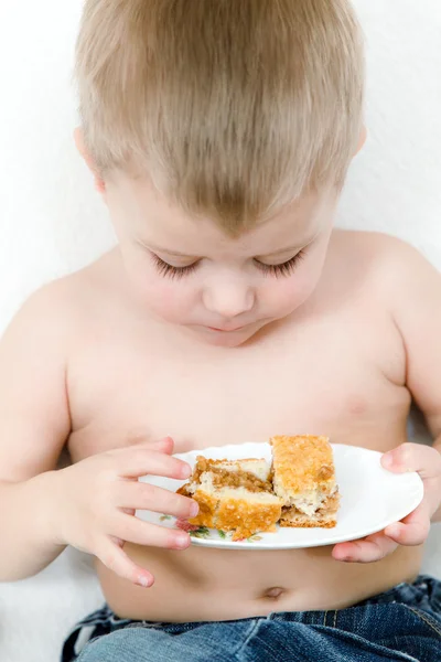 O rapaz à idade escolar com uma torta nas mãos — Fotografia de Stock