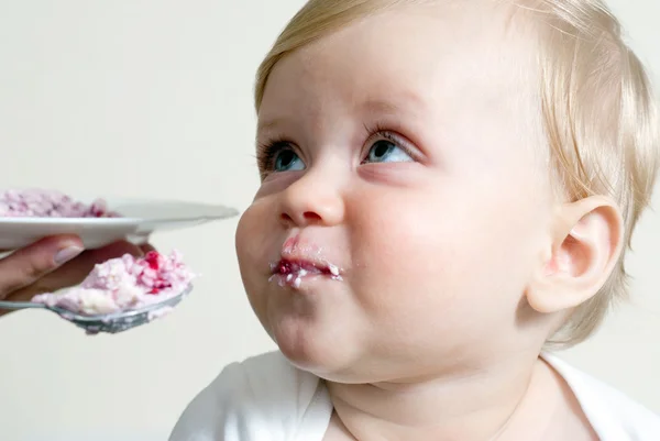 Malý chlapec jíst příkrmy se lžičkou — Stock fotografie