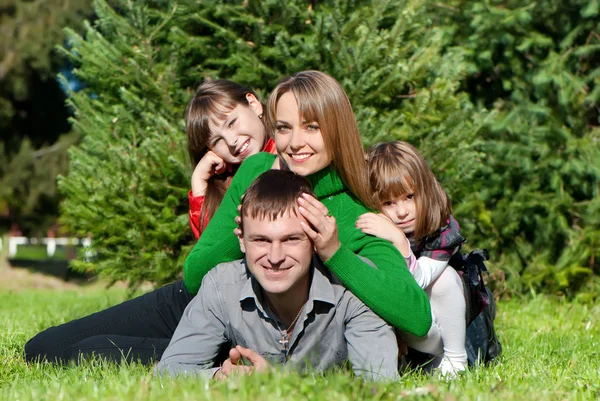 Pais e filhas felizes no parque — Fotografia de Stock