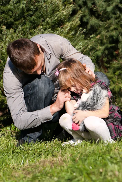 Плачущая маленькая девочка с отцом в парке — стоковое фото