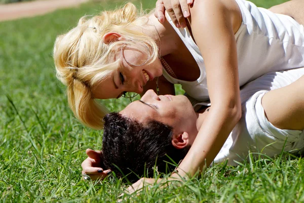 Lyckliga unga paret spelar på park i gräs — Stockfoto