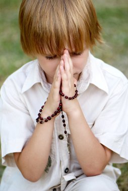 Young boy praying outdoors clipart