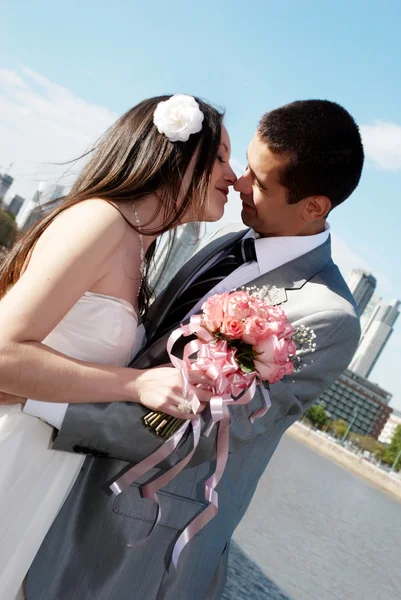 Heureux couple nouvellement marié contre une ville — Photo