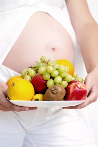 Pregnant woman holding fruits — Stock Photo, Image