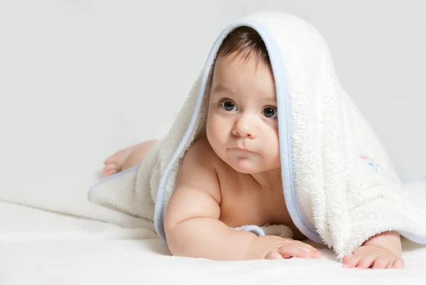 Pequeno bebê sob toalha branca — Fotografia de Stock