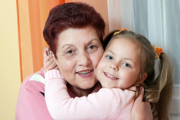 Closeup portrait of a grand daughter and grandmother smiling — Stock Photo, Image